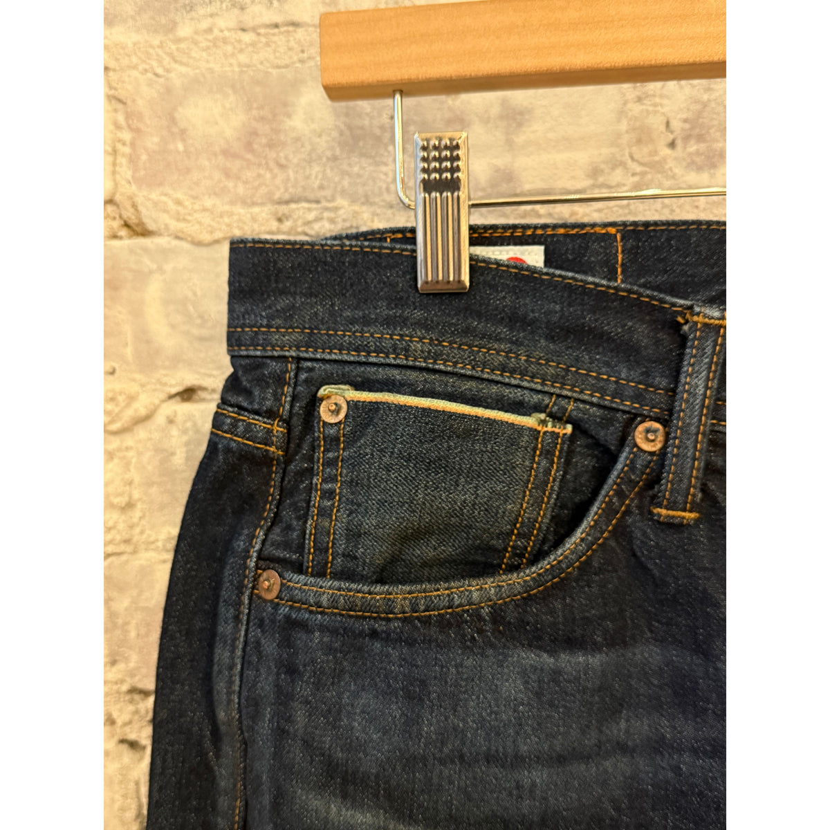 Men's Edwin Atika Straight 13.5oz selvage denim jeans in dark wash with 90-day wash fade, displayed hanging.