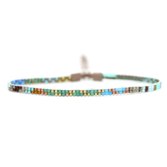 Julie Rofman Tanu Mini Bracelet, delicate gold-toned accessories with intricate design, close-up shot showing fine detailing.