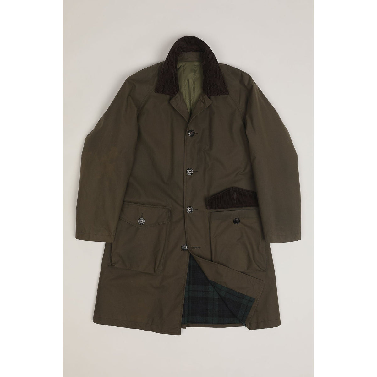 Men's green Baxter waxed cotton trench coat by East Harbour Surplus, shown hanging with collar and button details.