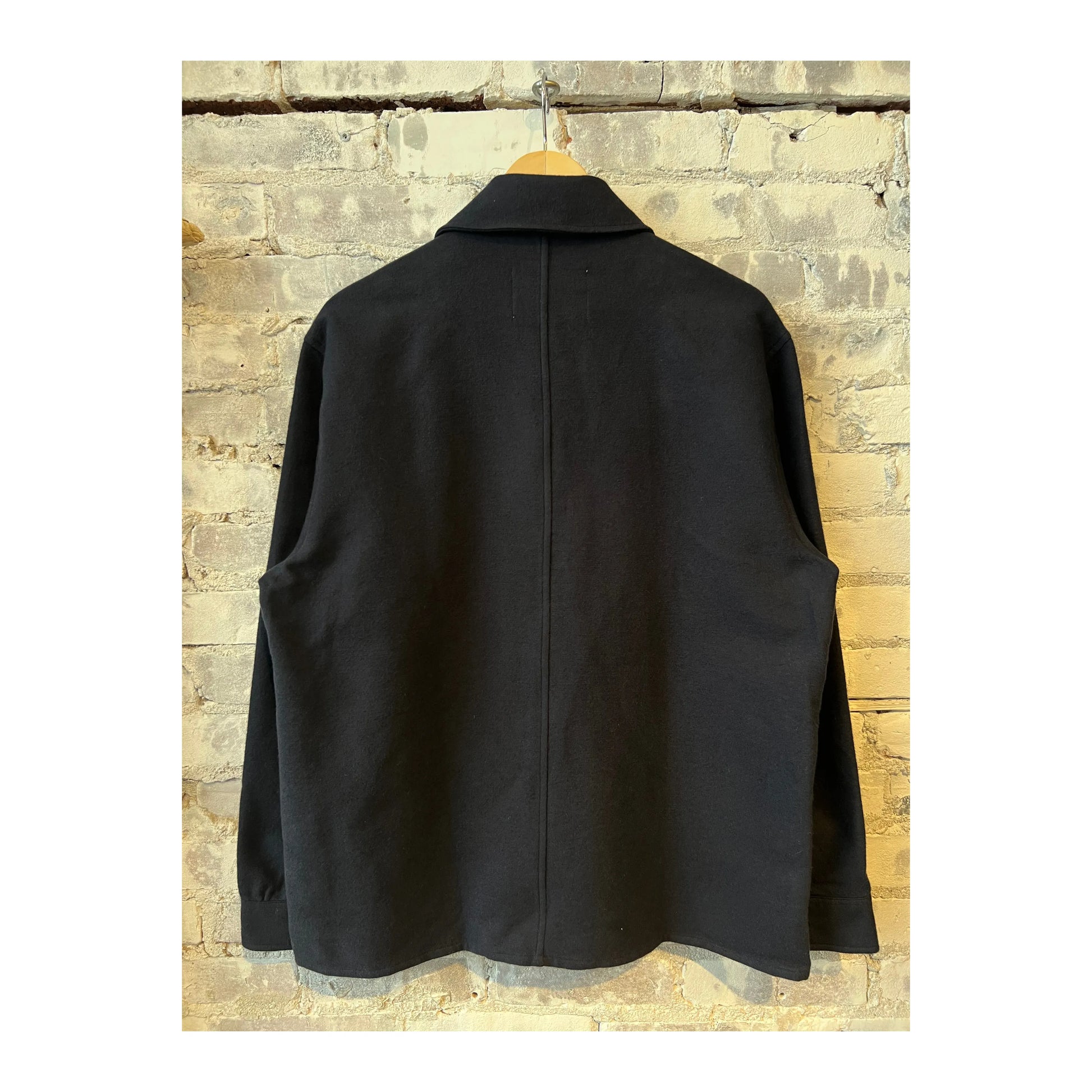 Men's navy Blaze Organic Cotton Overshirt by NN07, shown on a hanger with a button-up front and relaxed fit, casual style.