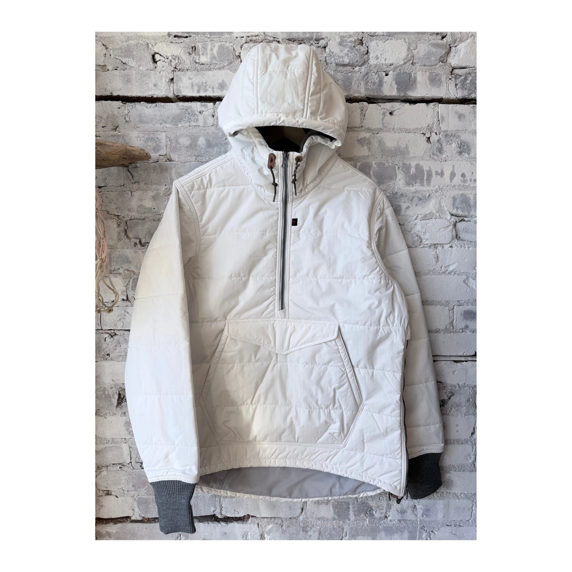 Men's white Boarder Anorak jacket by Relwen, featuring a lightweight design and adjustable hood, displayed on a hanger.