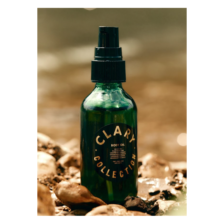 Small 2oz Clary Collection body oil accessory bottle with a sleek design and natural branding on the label.