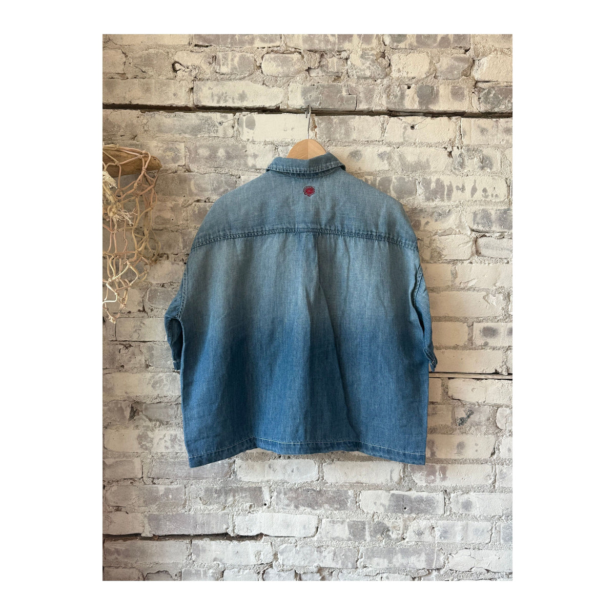 Men's light indigo chambray cropped shirt by MONOSTERO, showcasing the textured fabric and stylish cropped fit.