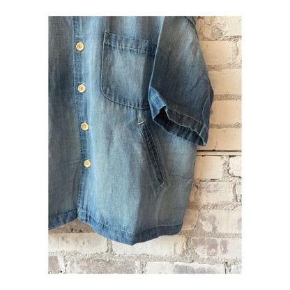 Men's light indigo chambray cropped shirt by MONOSTERO, showing a close-up of the fabric and front detail.