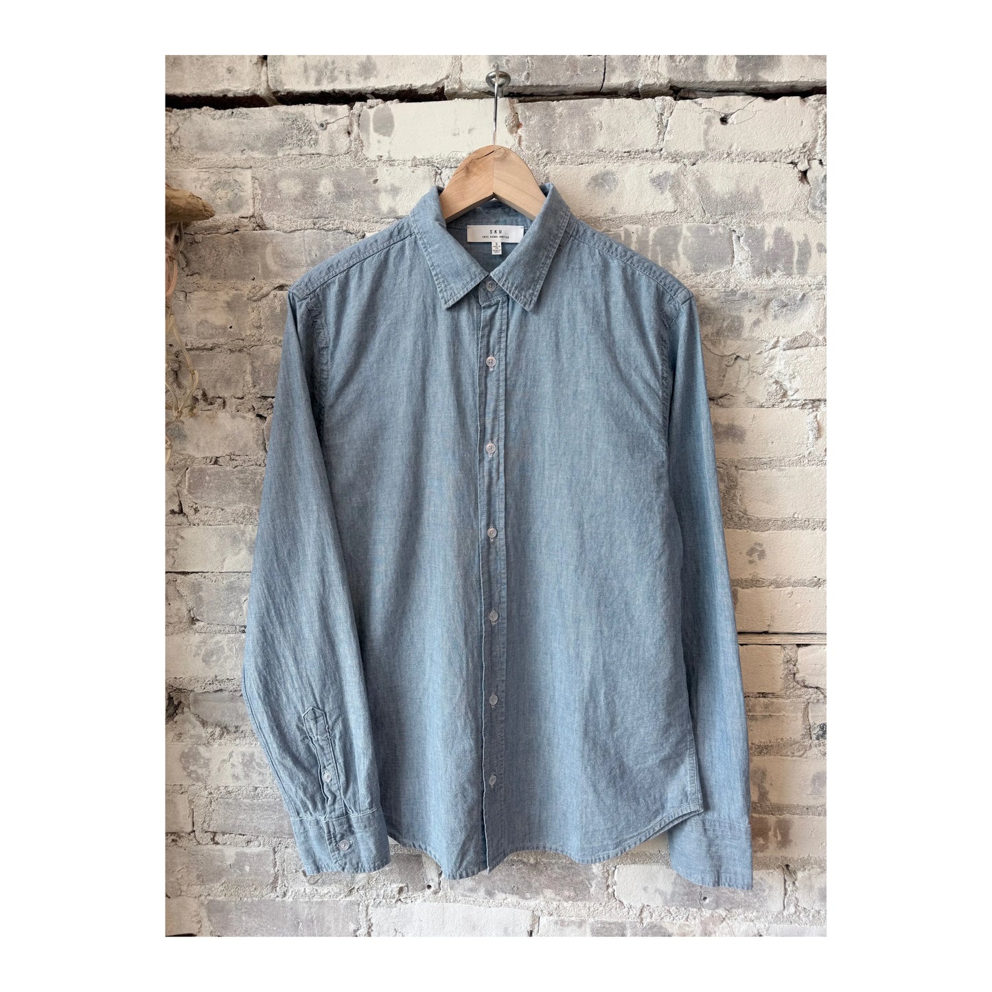 Men's chambray blue shirt by Save Khaki United, featuring a classic button-up style and casual fit.