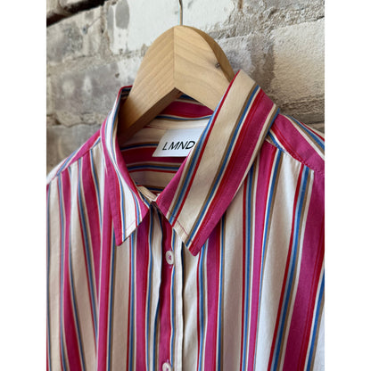Women's Chiara Midi Dress by LMND in vibrant fuchsia with multicolor stripes, displayed on a hanger against a neutral background.