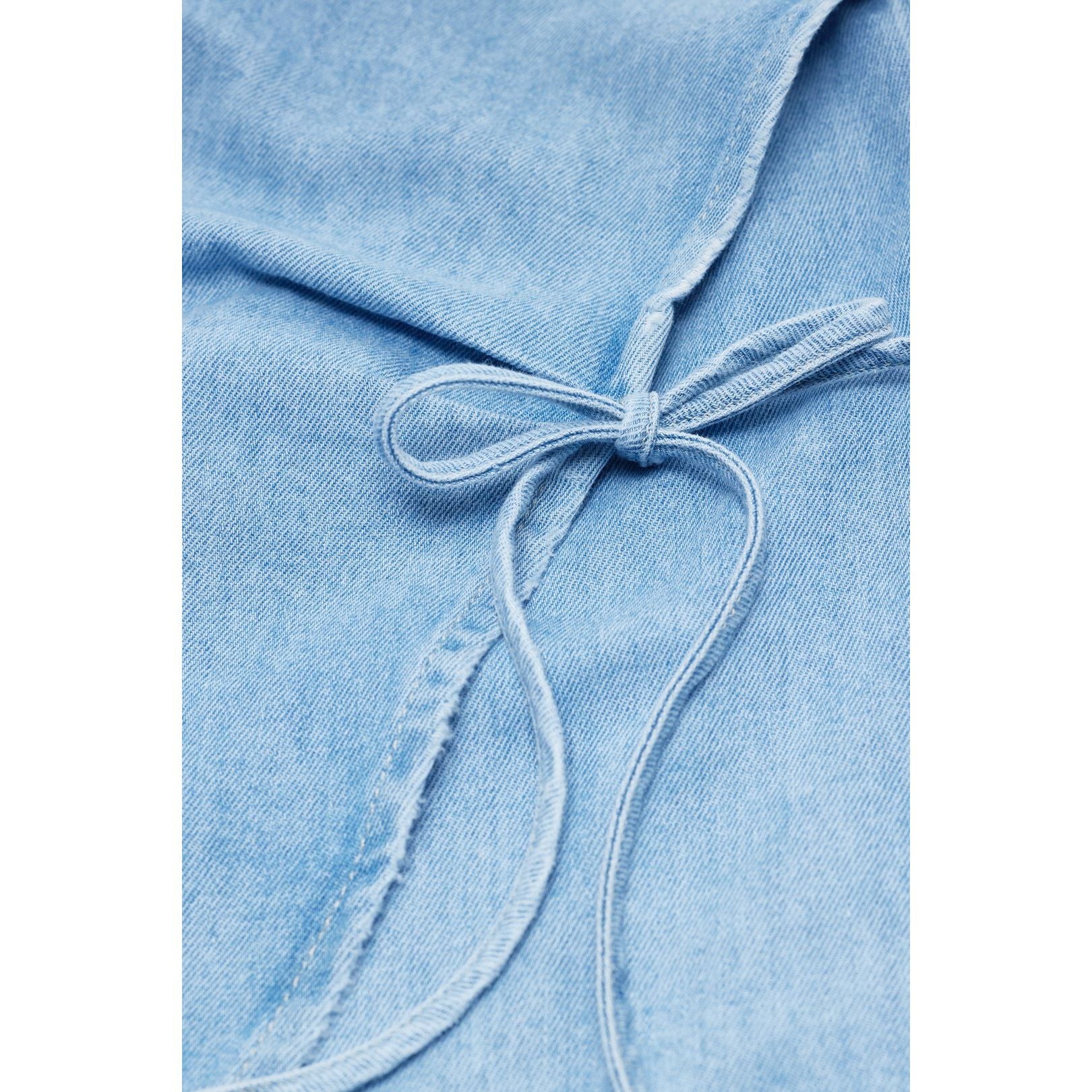 Light blue women's denim wrap top by Closed, shown on a model, featuring long sleeves and a fitted waist.