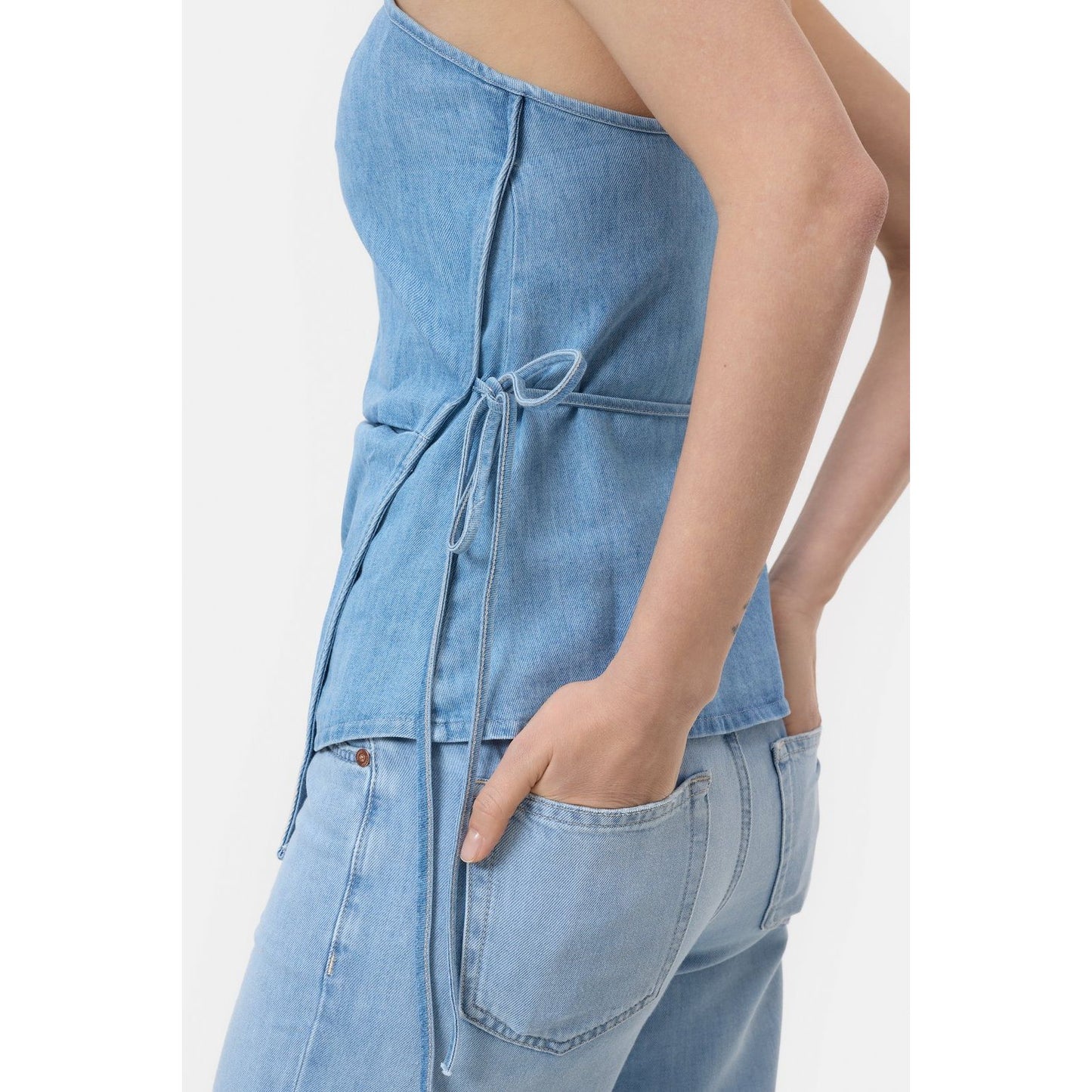 Light blue women's denim wrap top by Closed, shown on a model, featuring a stylish wrap design and long sleeves.