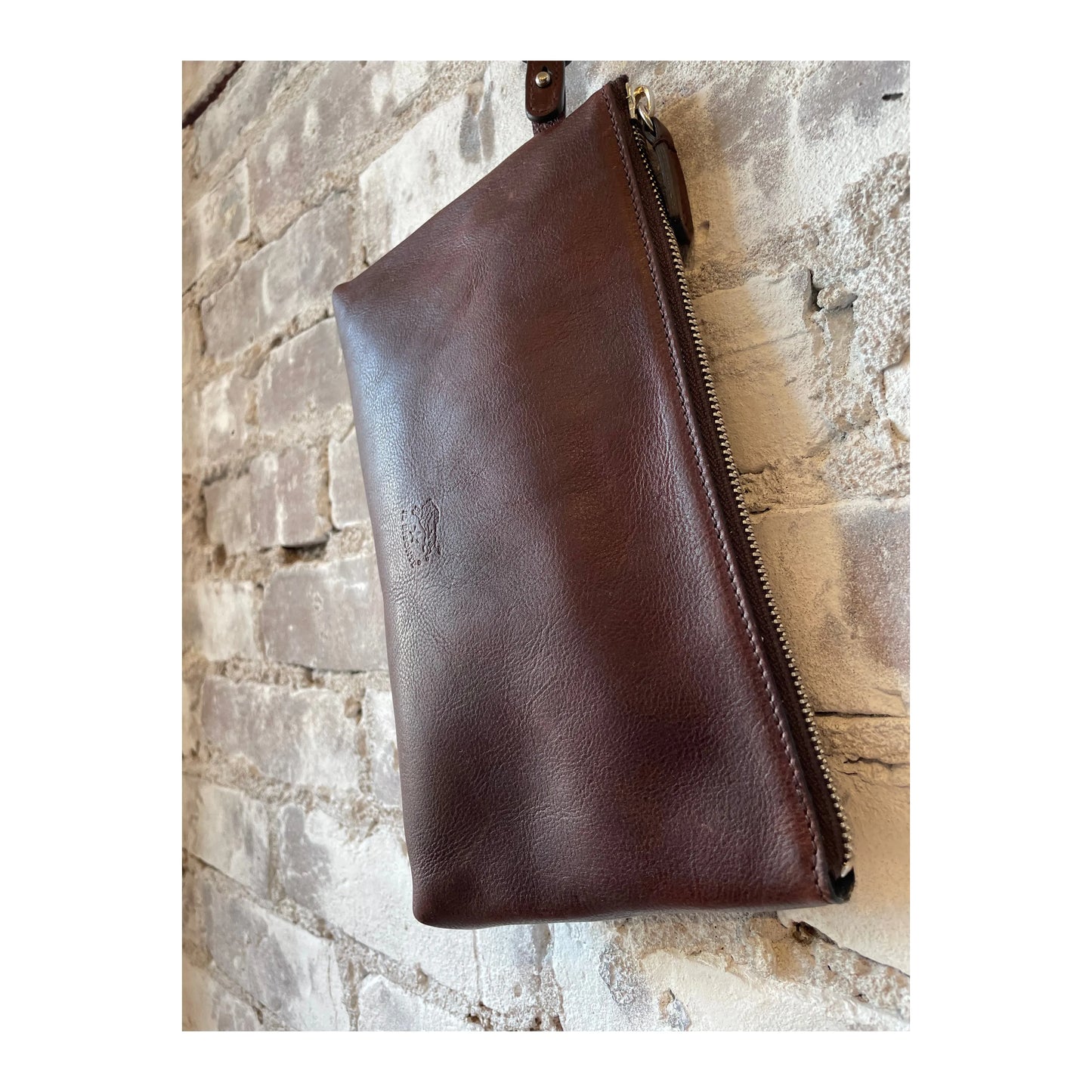 Women's Caffé Clutch Oriuolo by Il Bisonte, shown in a close-up of the stylish, textured leather clutch bag with a compact design.