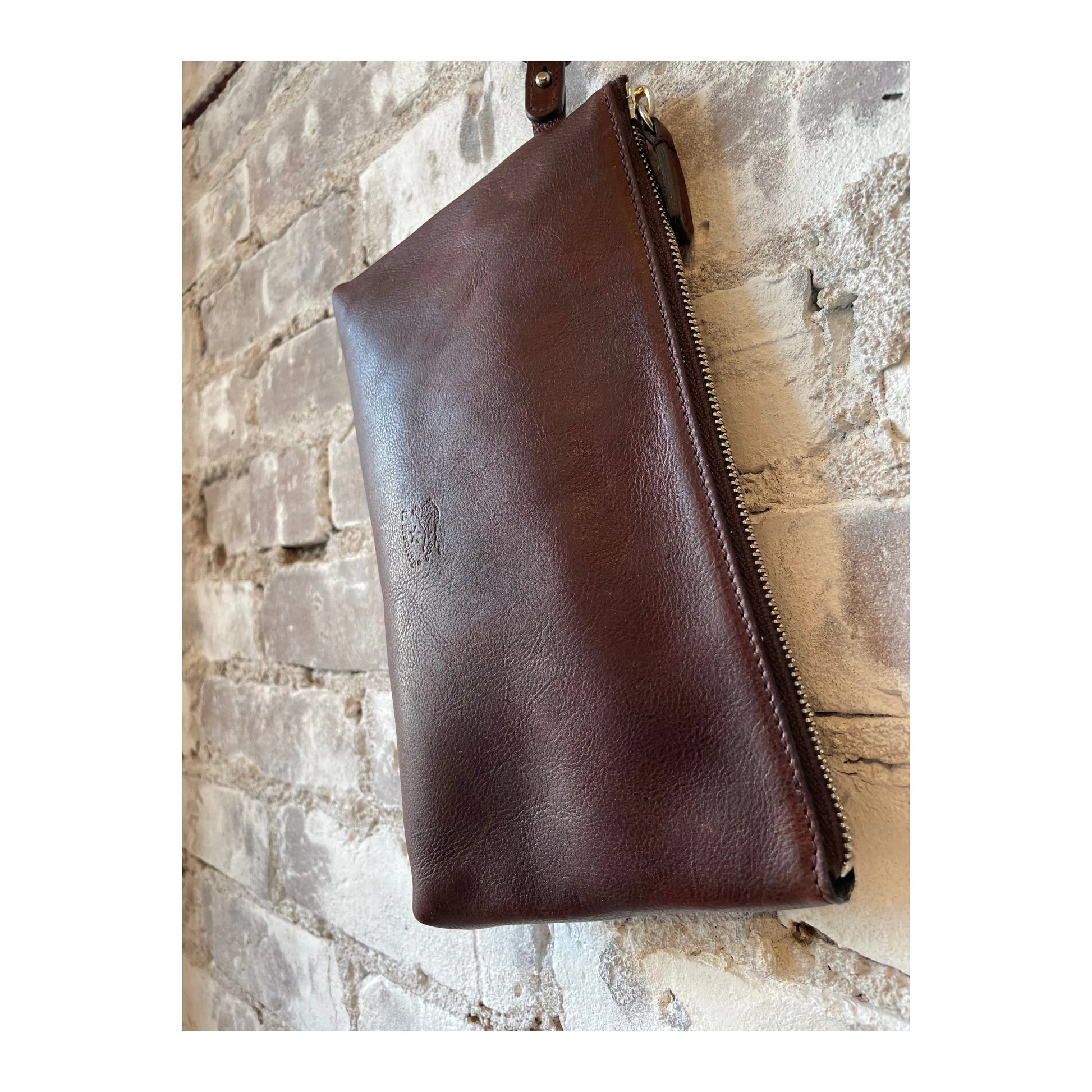 Women's Caffé Clutch Oriuolo by Il Bisonte, shown in a close-up of the stylish, textured leather clutch bag with a compact design.