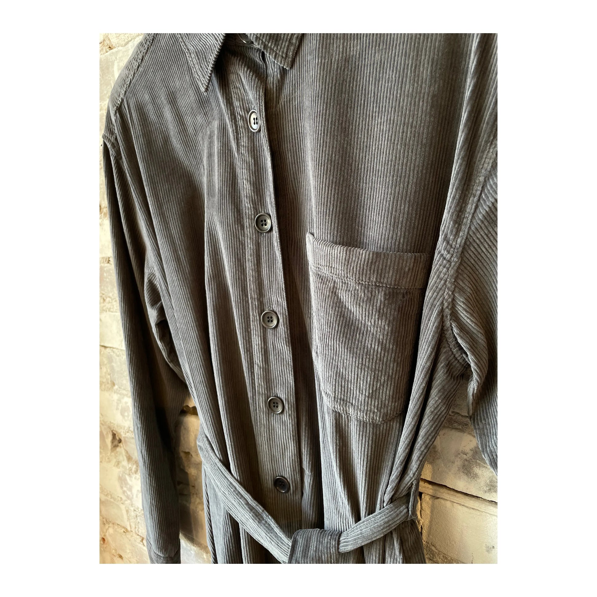 Charcoal Hartford Women's Corduroy Revol Dress displayed on a hanger, showing its textured fabric and classic style.