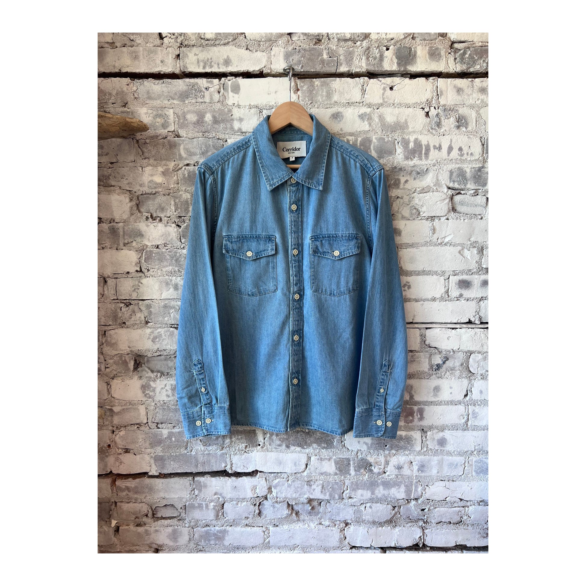 Men's light indigo denim shirt by Corridor, long-sleeve casual shirt with button-up front and classic denim texture.