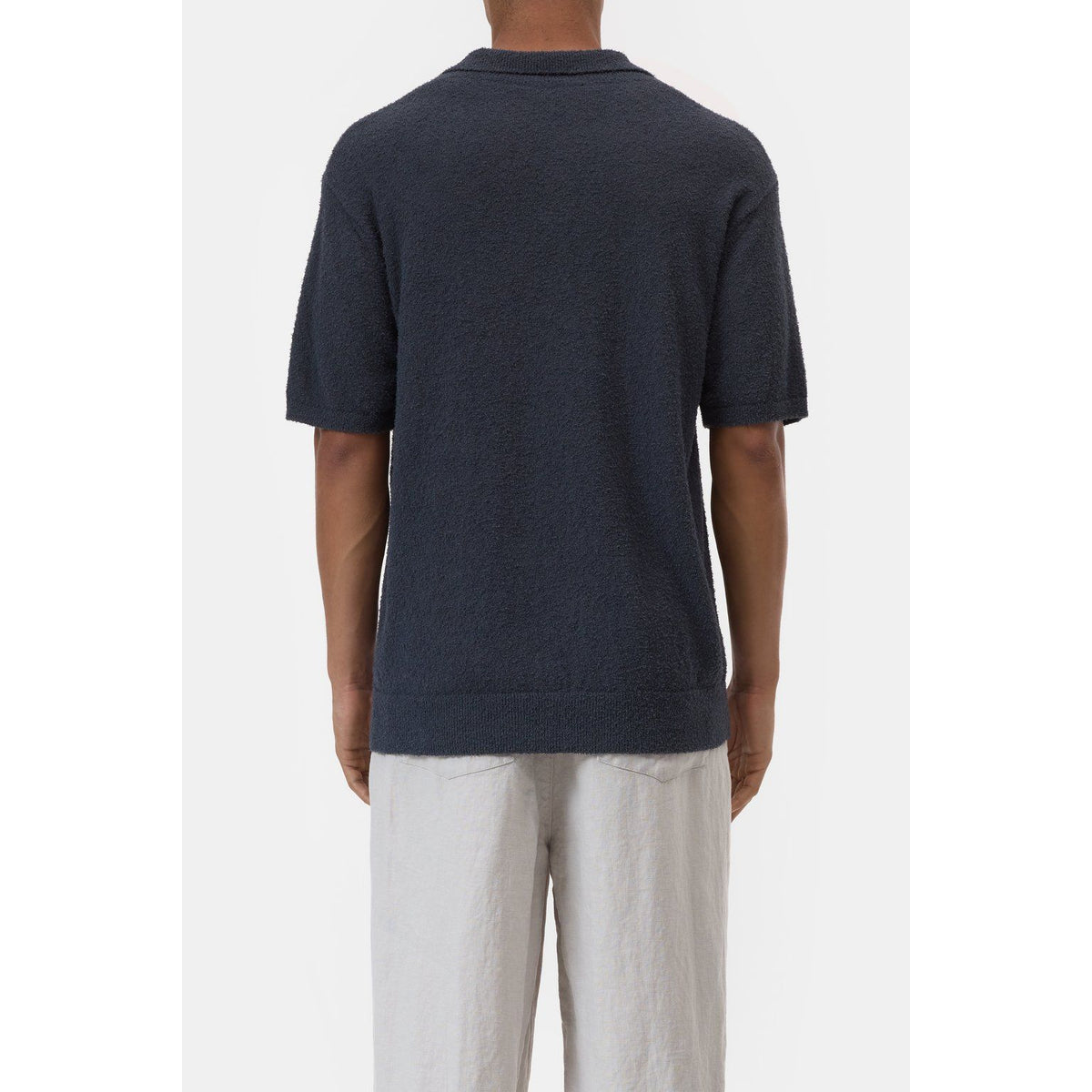 Men's Cotton Knit Polo in Magma Black by Closed Men's, showing the black polo with a classic collar and textured knit fabric.