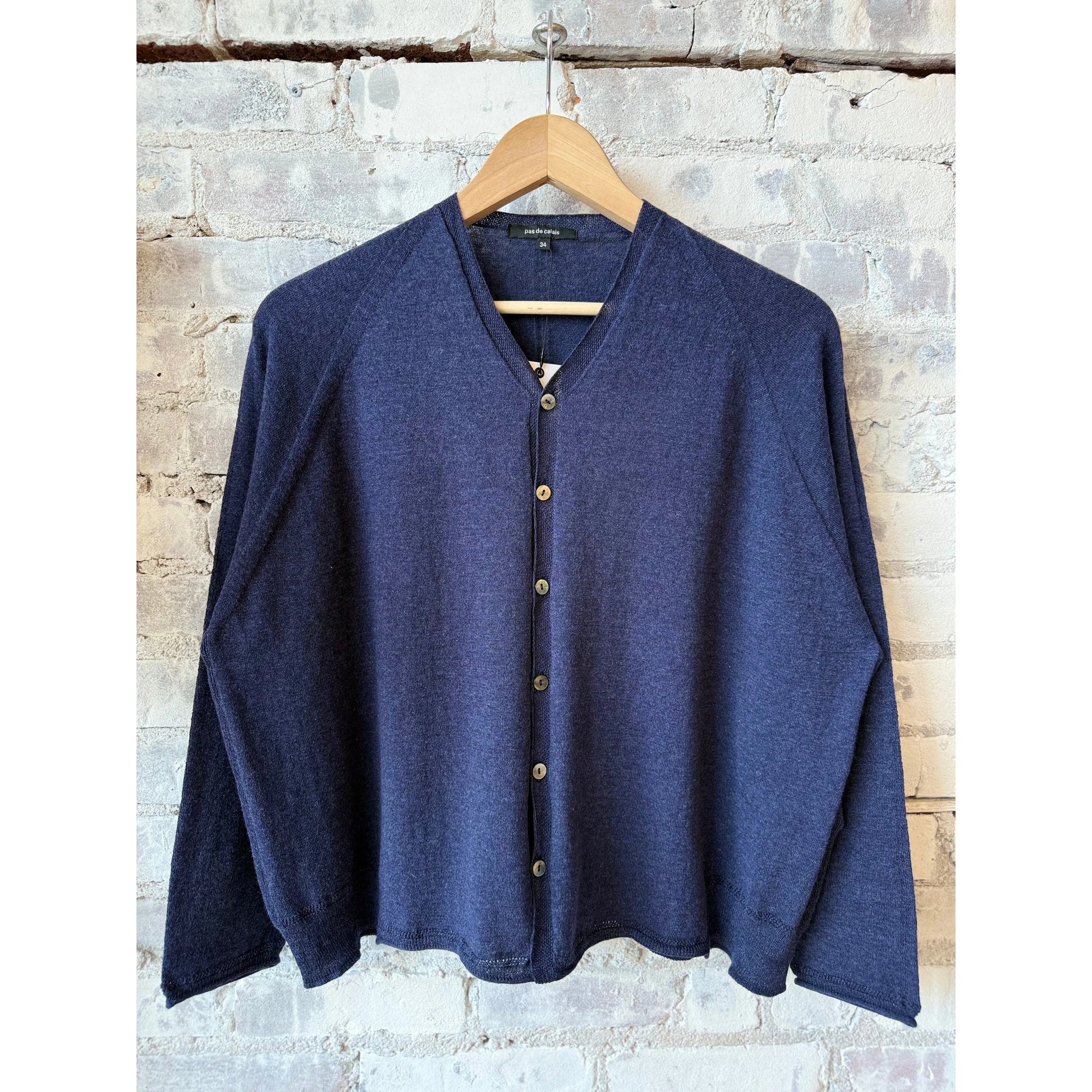 Women's navy cotton-linen V-neck cardigan sweater by Pas De Calais, displayed flat to show knit texture and design details.