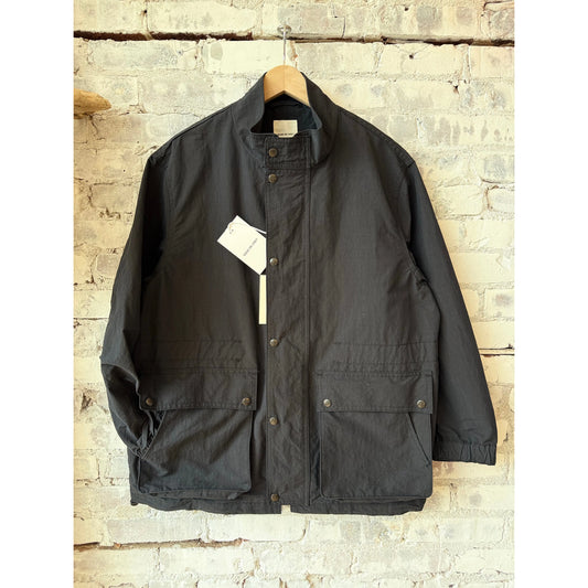 Men's black shirt jacket by Sage De Cret with typewriter stand collar, made from cotton and nylon, featuring a stylish, fitted design.