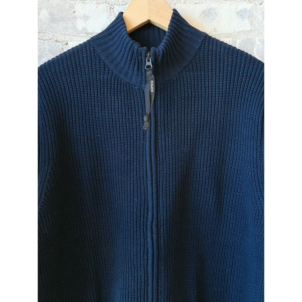 Men's navy cotton-yarn zip-up sweater by Aspesi, featuring a high collar and ribbed cuffs, displayed on a hanger.