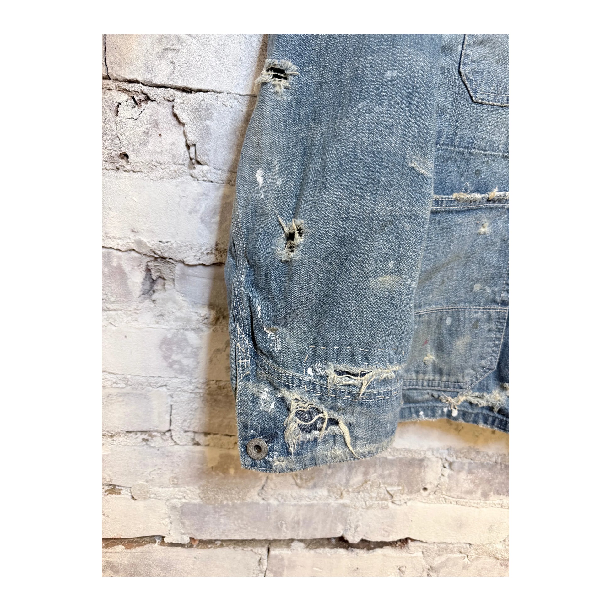 Men's indigo denim coverall jacket by H-Unit, customized with visible stitching and functional pockets, displayed on a hanger.