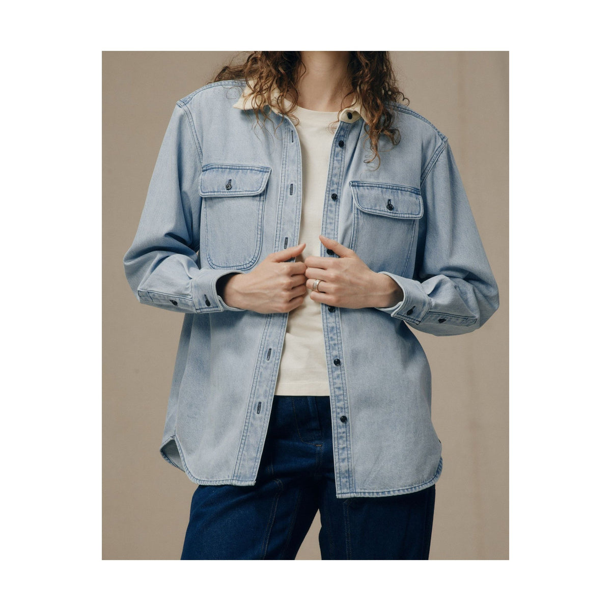 Women's light indigo denim work shirt by FILSON, featuring a classic button-up design and rugged denim fabric.