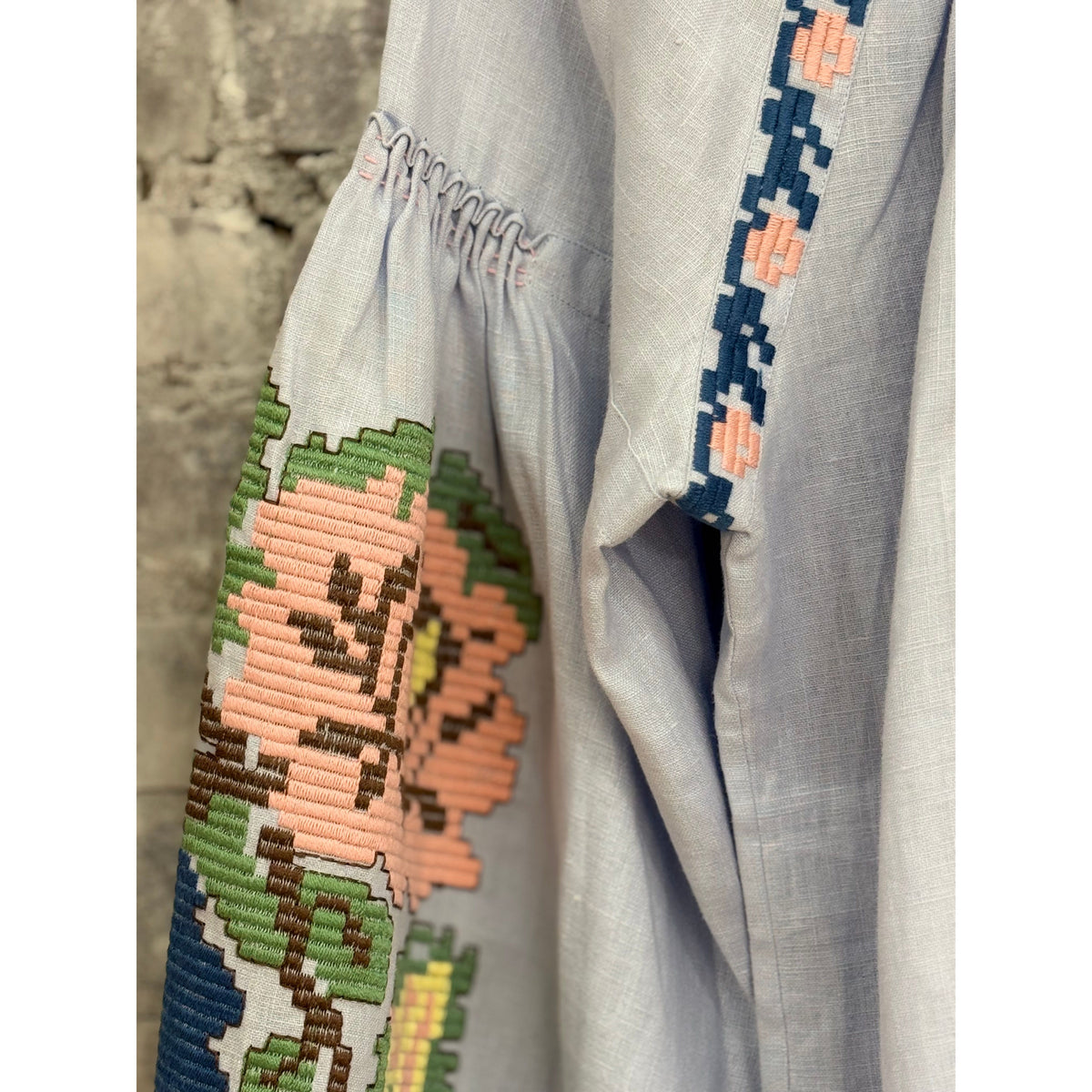 Light blue women's Elysian Whisper Blouse by Annabo displayed on a hanger with soft fabric details visible.