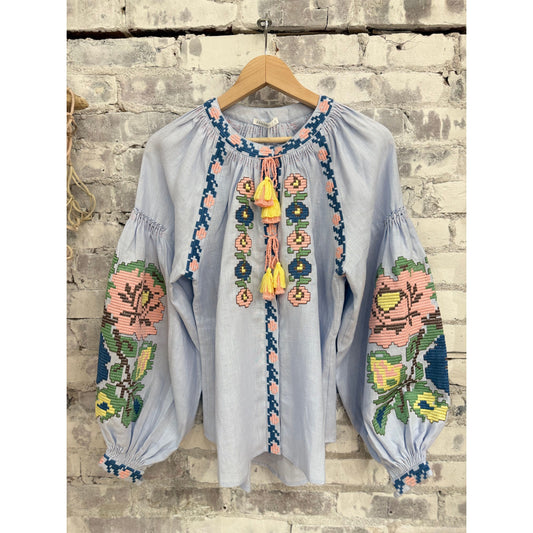 Light blue Annabo women's Elysian Whisper blouse, soft fabric with a relaxed fit and subtle detailing, displayed on a hanger.