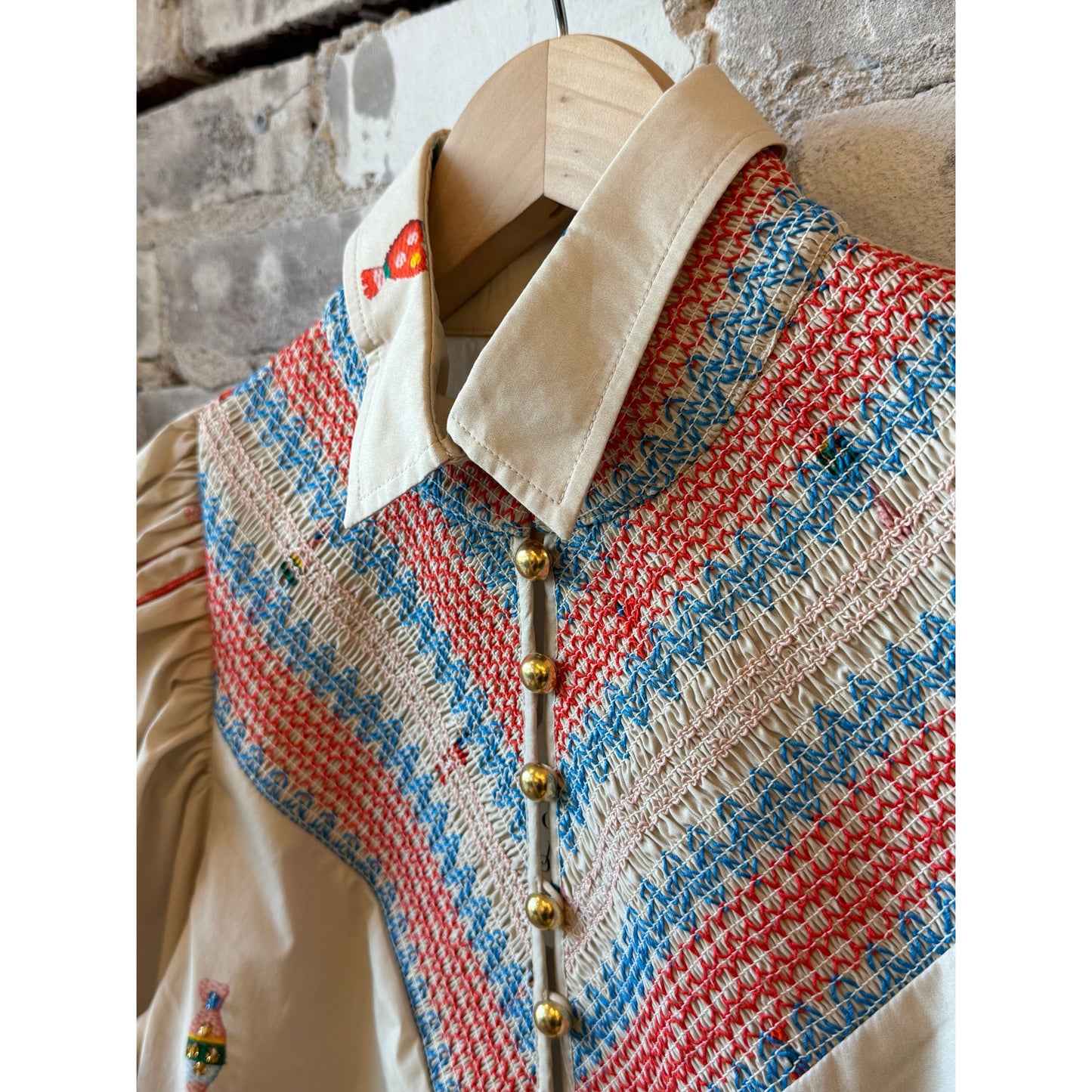 Women's embroidered smocked shirt in vanilla with colorful floral embroidery, by Hope For Flowers, showing intricate embroidery details.