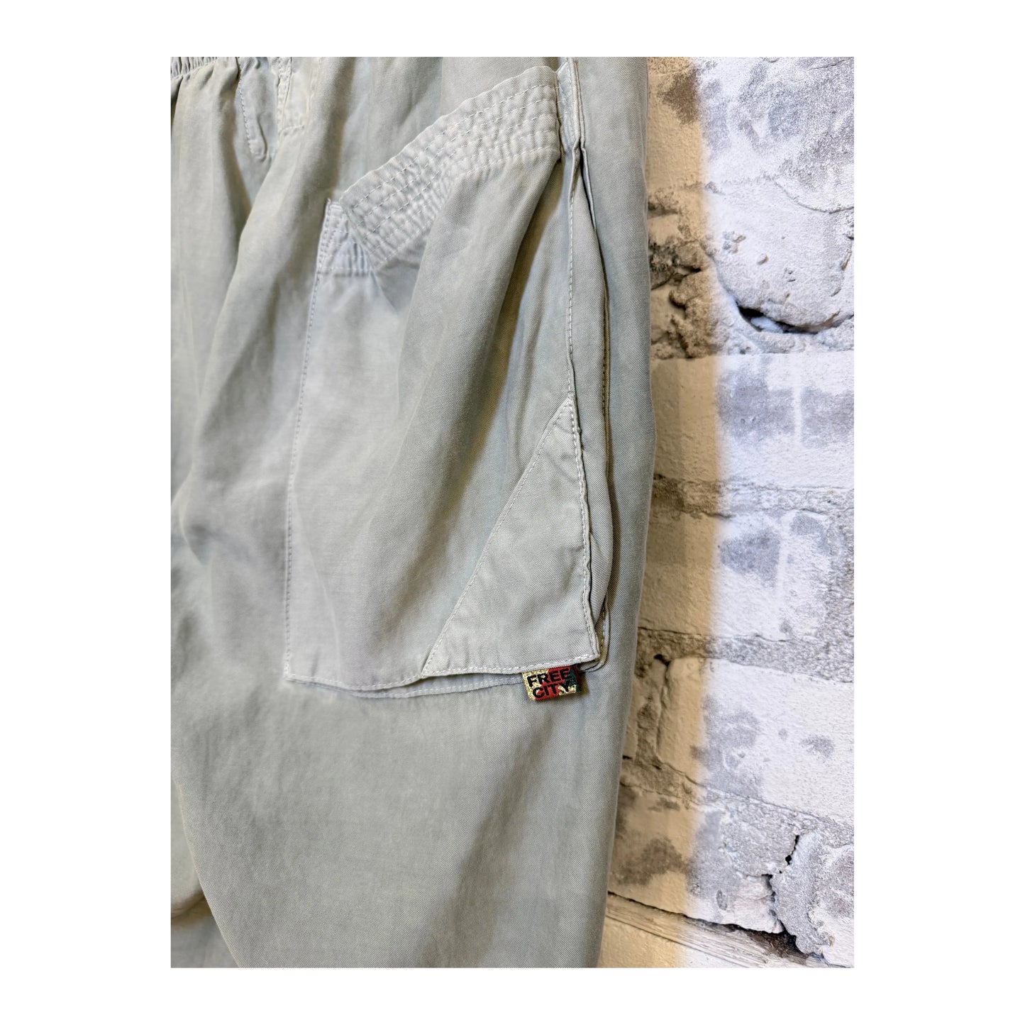 Women's Freecity AirJump pants in silver rock with flap and snap-free matte satin fabric, shown in a stylish side view.