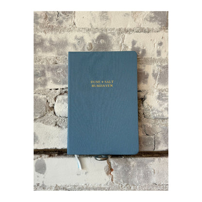 Foil embossed linen notebook in dusty blue and gold by Studio Portmanteau, featuring a textured cover and elegant design.