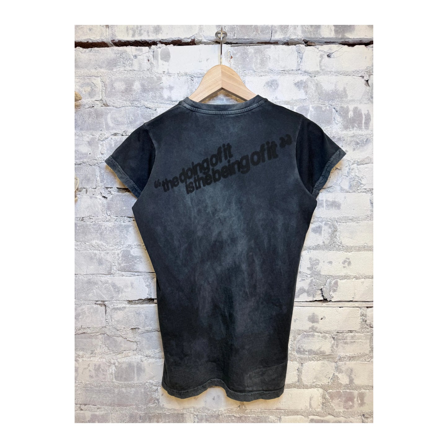 Women's Freecity "the doing of it is the being of it" vintage-style short-sleeve T-shirt with volcano powder color and relaxed fit.