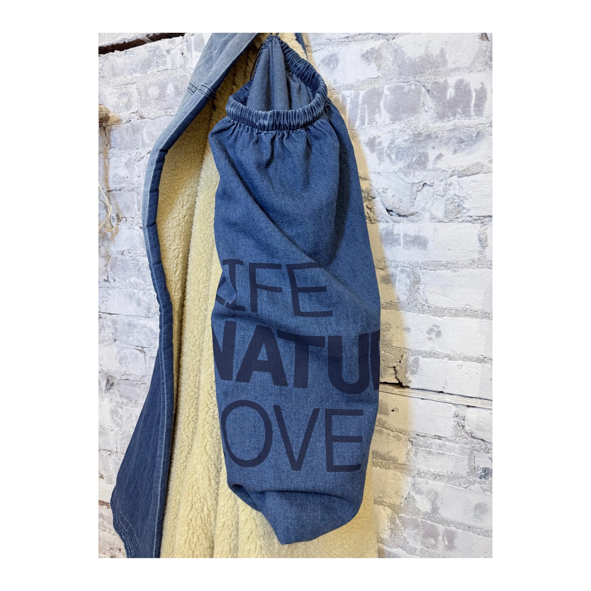 Freecity x Commune indigo sherpa-bear blanket draped over a cozy sofa, showcasing its soft indigo blues and plush texture.