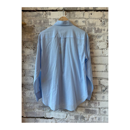 Light periwinkle women's airy shirt by G1 Women's, shown hanging on a hanger with soft fabric details visible.