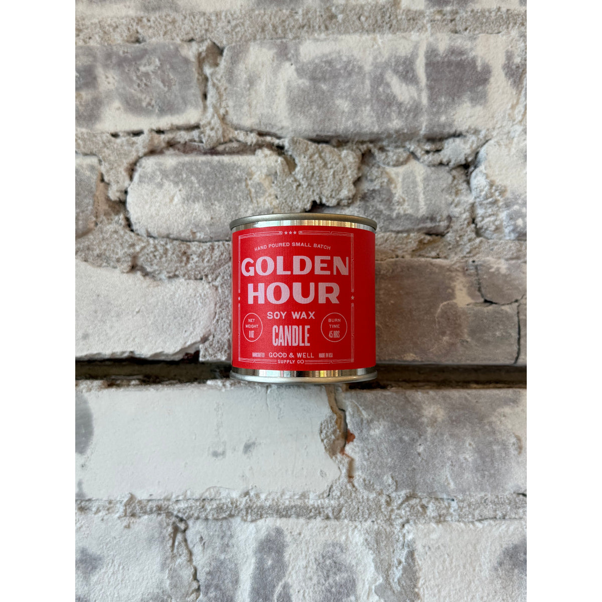 Golden Hour soy candle by Good & Well Supply Co. in a glass jar, emitting a warm, inviting glow as a home accessory.