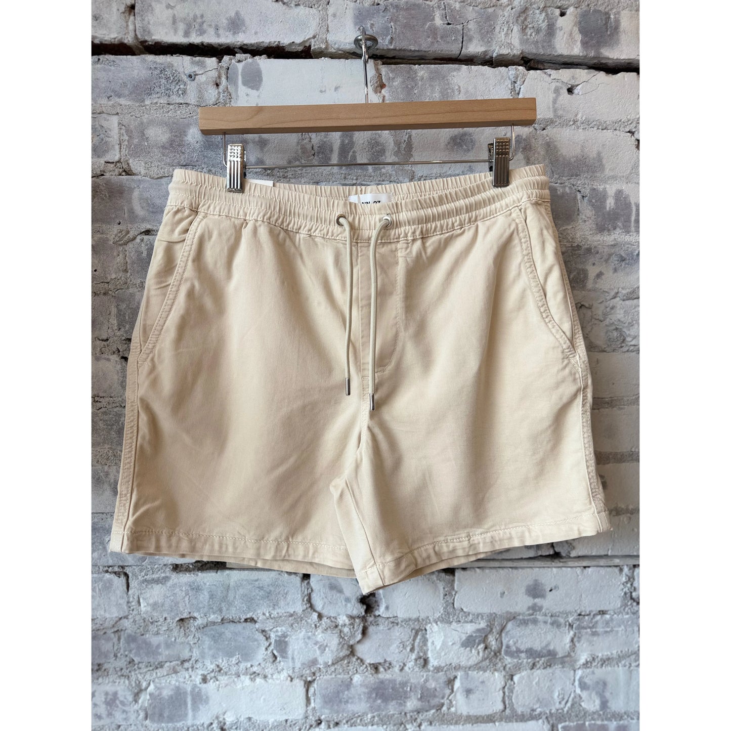 Men's NN07 Gregor Lyocell Blend Shorts in ivory, lightweight and comfortable, shown folded with a casual fit and smooth fabric.