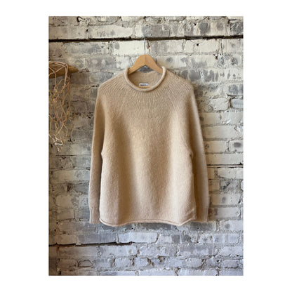 Cream women's handloom rollneck sweater by Bare Knitwear, showing the cozy knit fabric and fitted design.