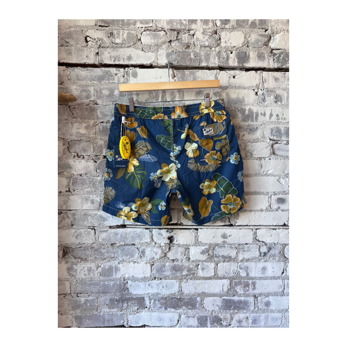 Men's navy swim trunks with hibiscus print made from recycled nylon by Hartford Men's, featuring a vibrant floral design.