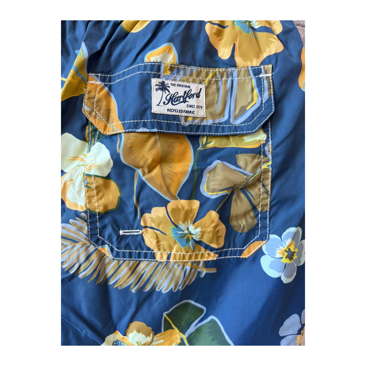 Men's navy Hibiscus printed swim trunks by Hartford Men's made from recycled nylon, featuring vibrant floral design.