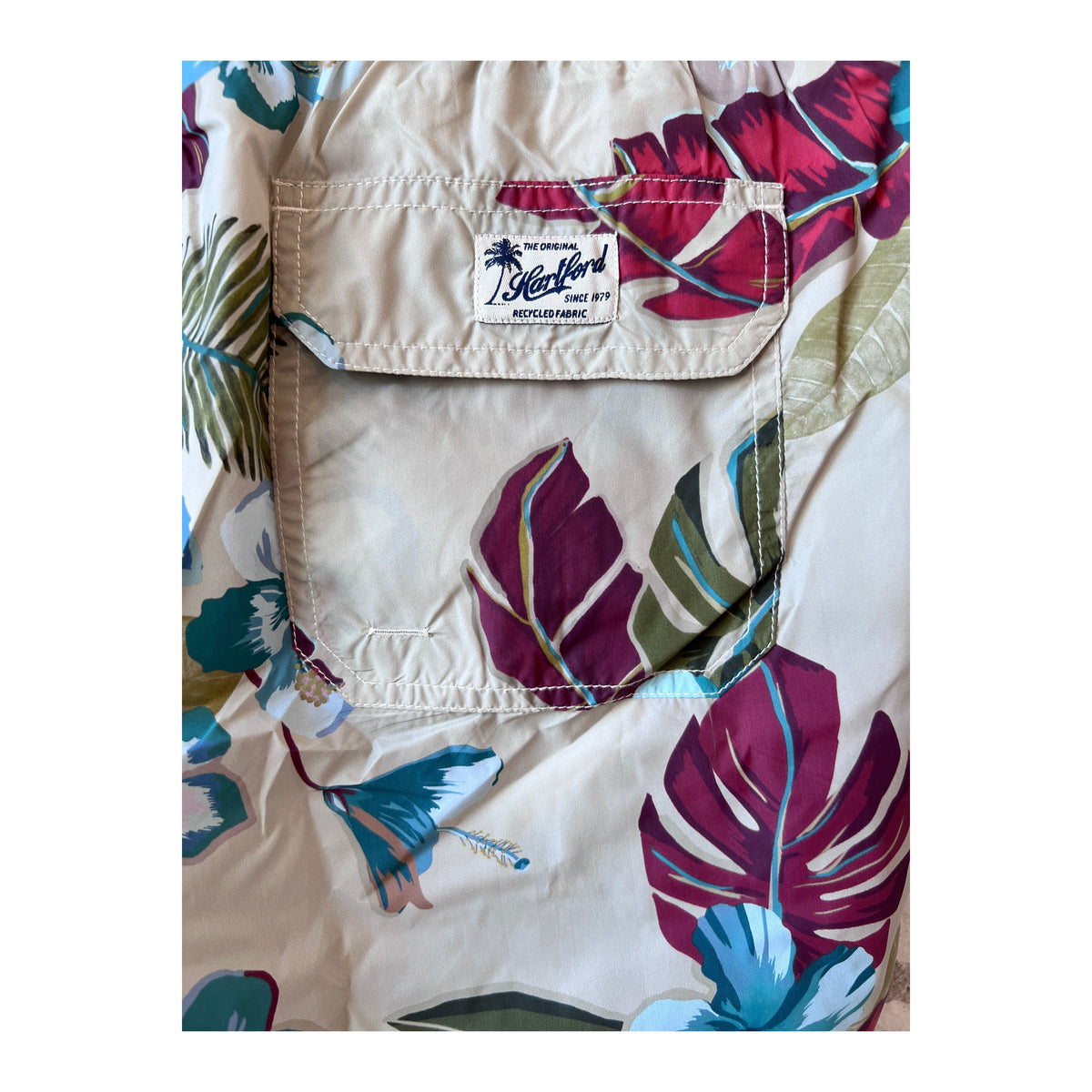 Men's Hartford Hibiscus printed recycle nylon swim trunks in sand color, featuring vibrant hibiscus floral design for beachwear.