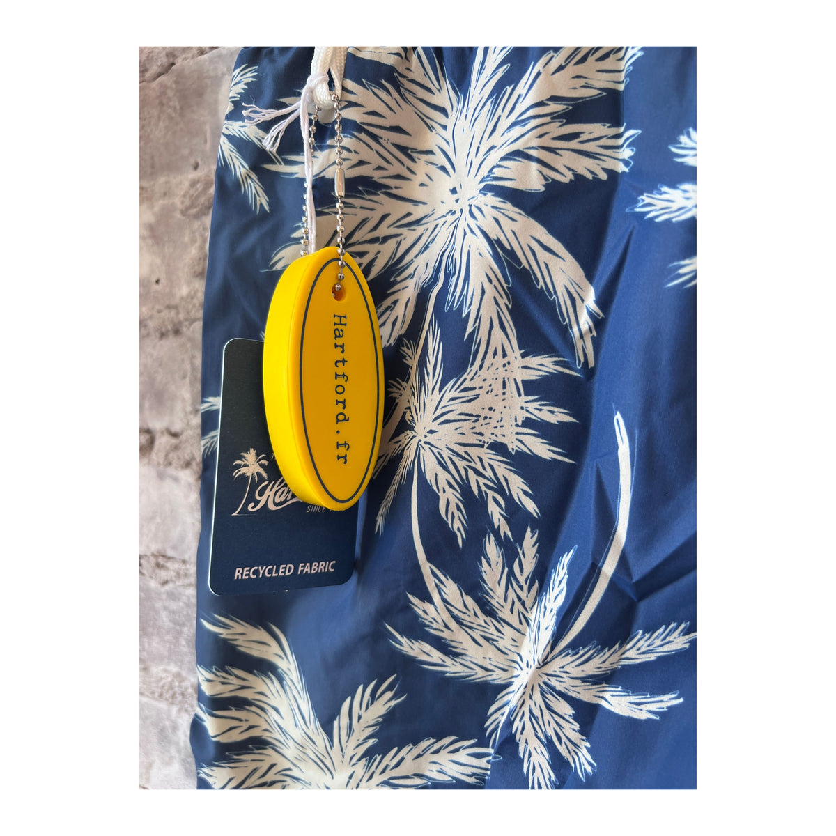Men's navy swim trunks with palm print made from recycled nylon, stylish Hartford Men's swimwear for beach or pool days.
