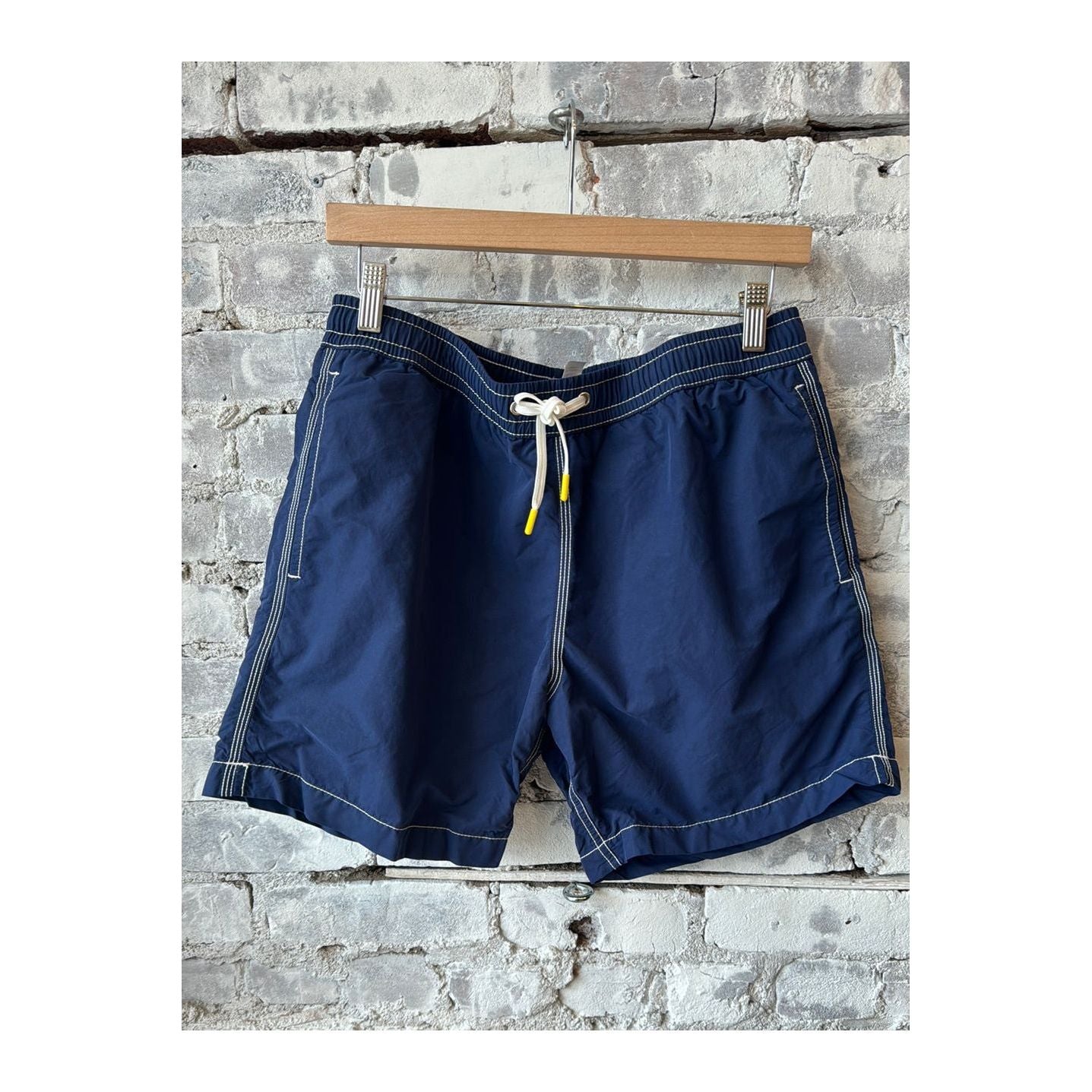 Men's classic deep blue swim shorts with matching pochette by Hartford Men's, casual summer beachwear ensemble.