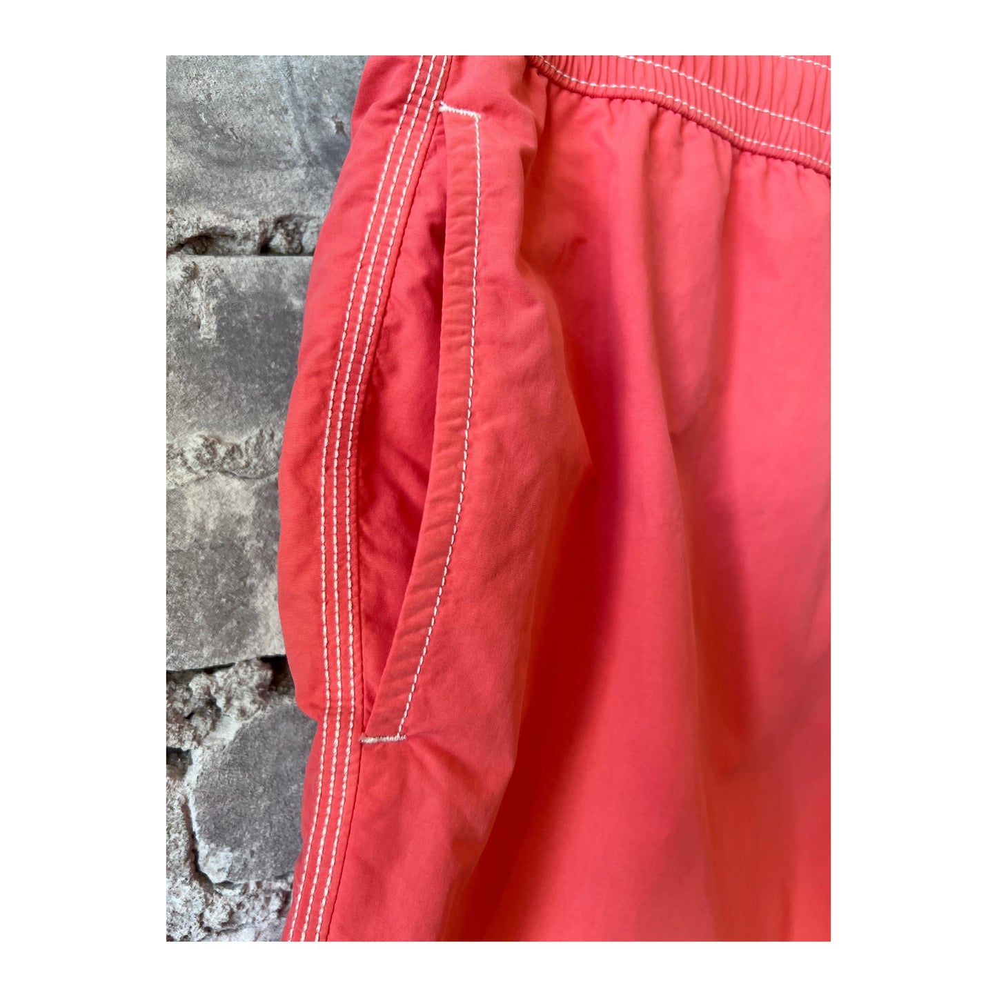 Men's Hartford Classic Swim Trunks in faded coral with matching pochette, featuring a relaxed fit and vibrant beach-ready style.