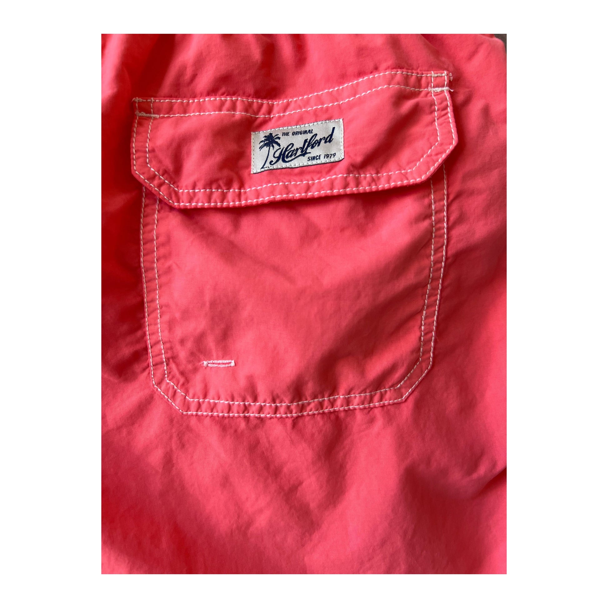 Men's faded coral classic swim trunks with matching pochette by Hartford Men's, featuring a relaxed fit and tropical style.