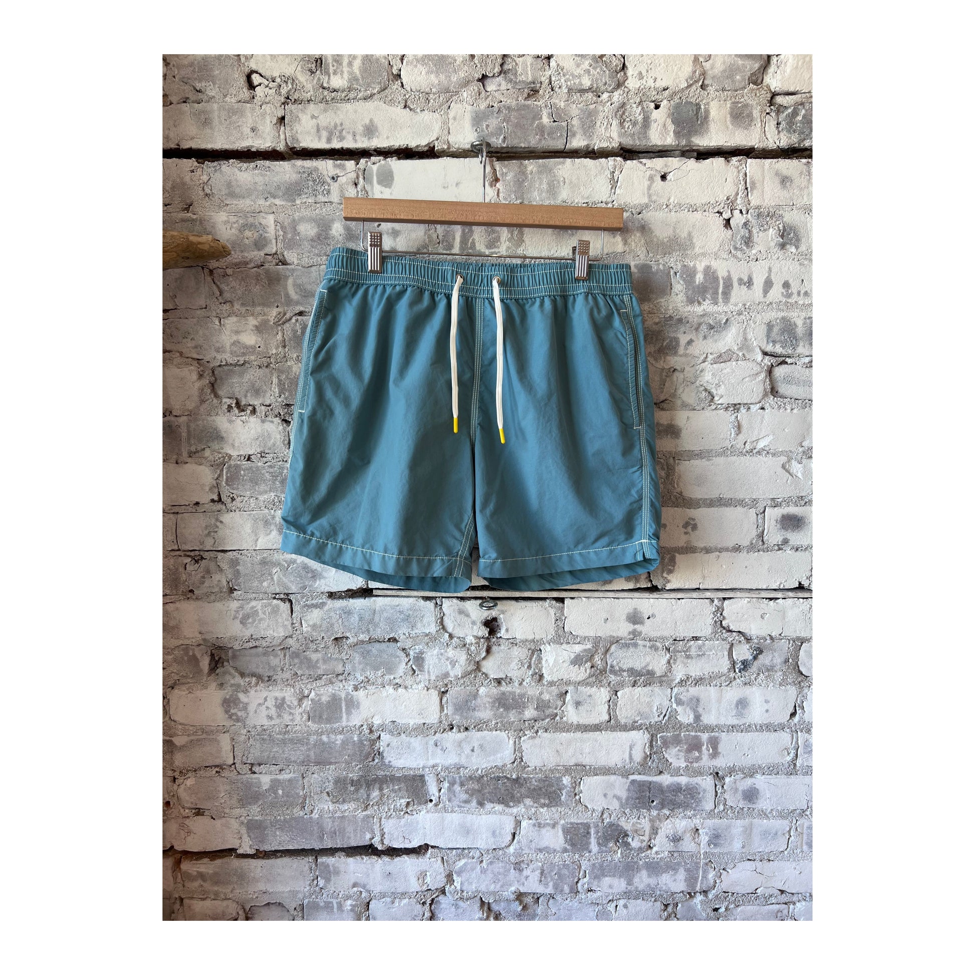 Men's classic swim trunks and matching pochette in sage from Hartford Men's, featuring a comfortable fit and stylish design.