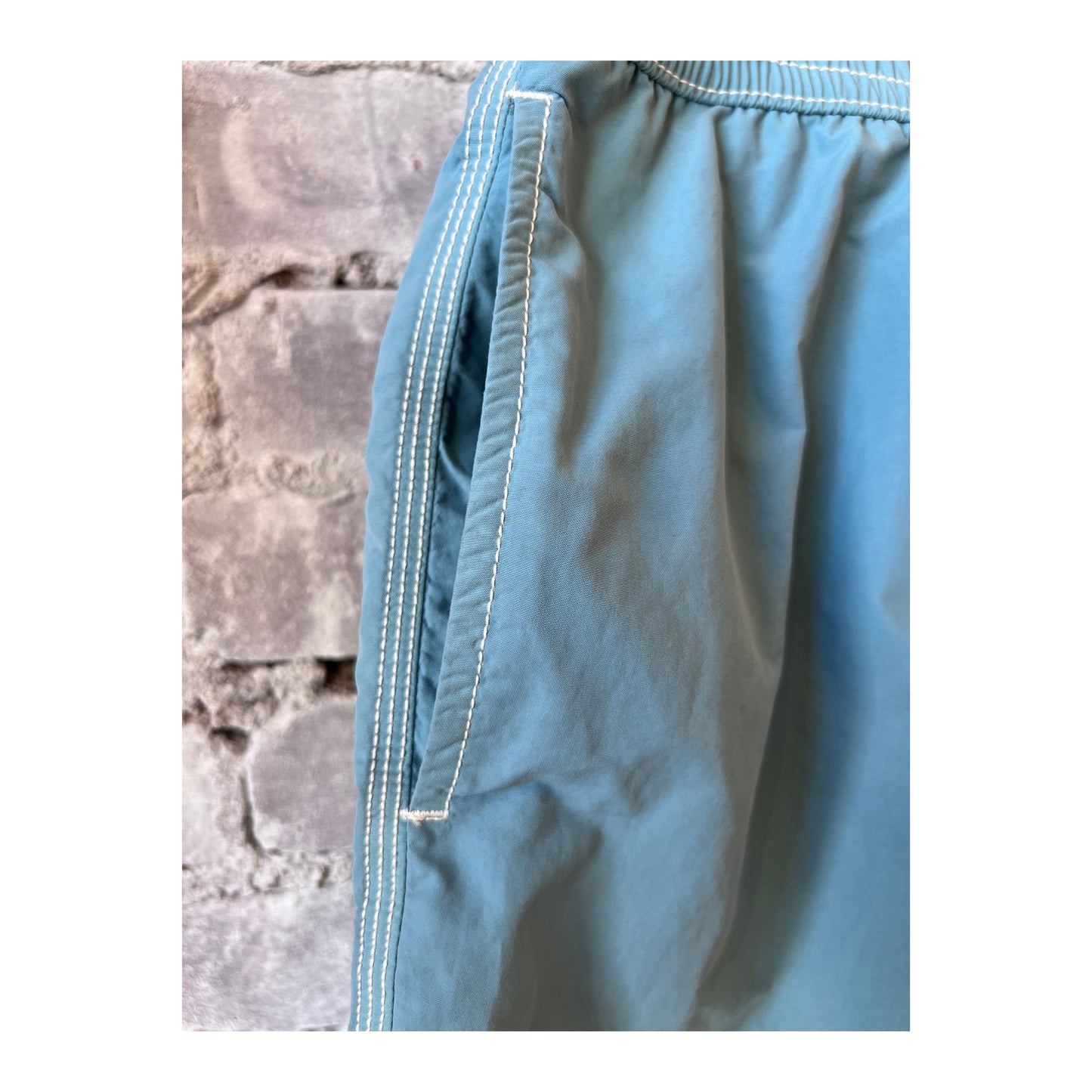 Men's Hartford Classic Swim Trunks in sage color with matching pochette, designed for stylish summer beachwear.