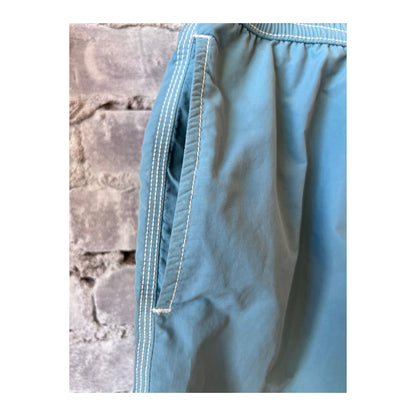 Men's Hartford Classic Swim Trunks in sage color with matching pochette, designed for stylish summer beachwear.