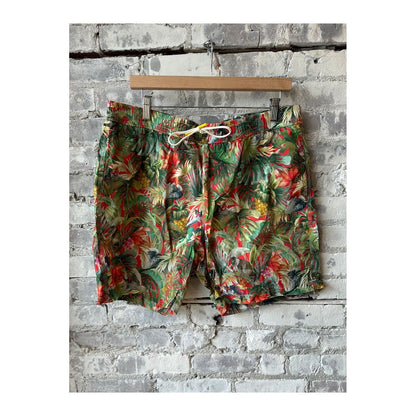 Men's printed swim shorts in jungle red by Hartford Men's, showing vibrant tropical jungle leaf pattern.