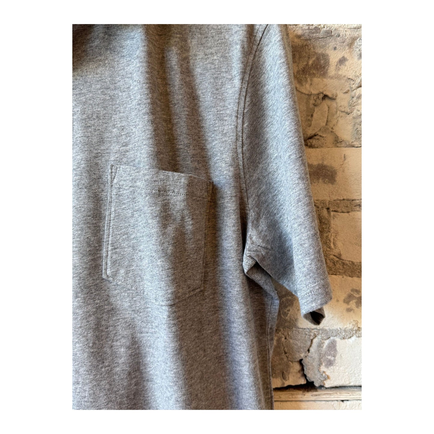Men's Hartford Heather Grey SS Cotton Jersey Polo shirt displayed on a hanger, showcasing its classic polo design and soft fabric.