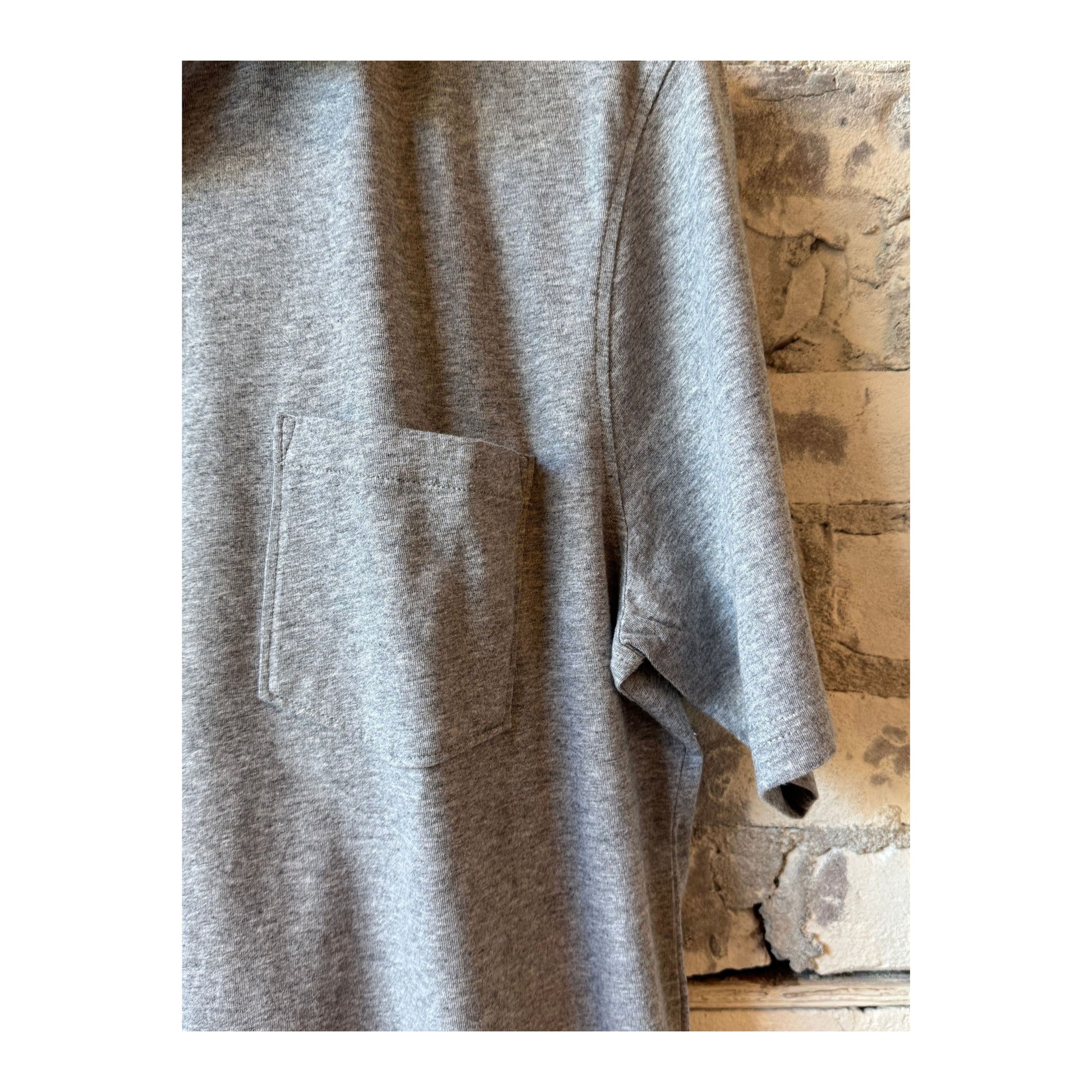 Men's Hartford Heather Grey SS Cotton Jersey Polo shirt displayed on a hanger, showcasing its classic polo design and soft fabric.
