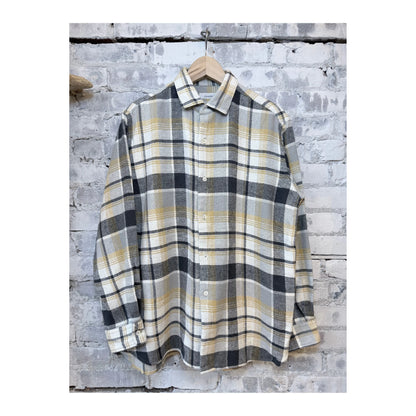 Men's heavy flannel shirt by nanamica in beige and gray plaid, showing a close-up of the fabric and button details.