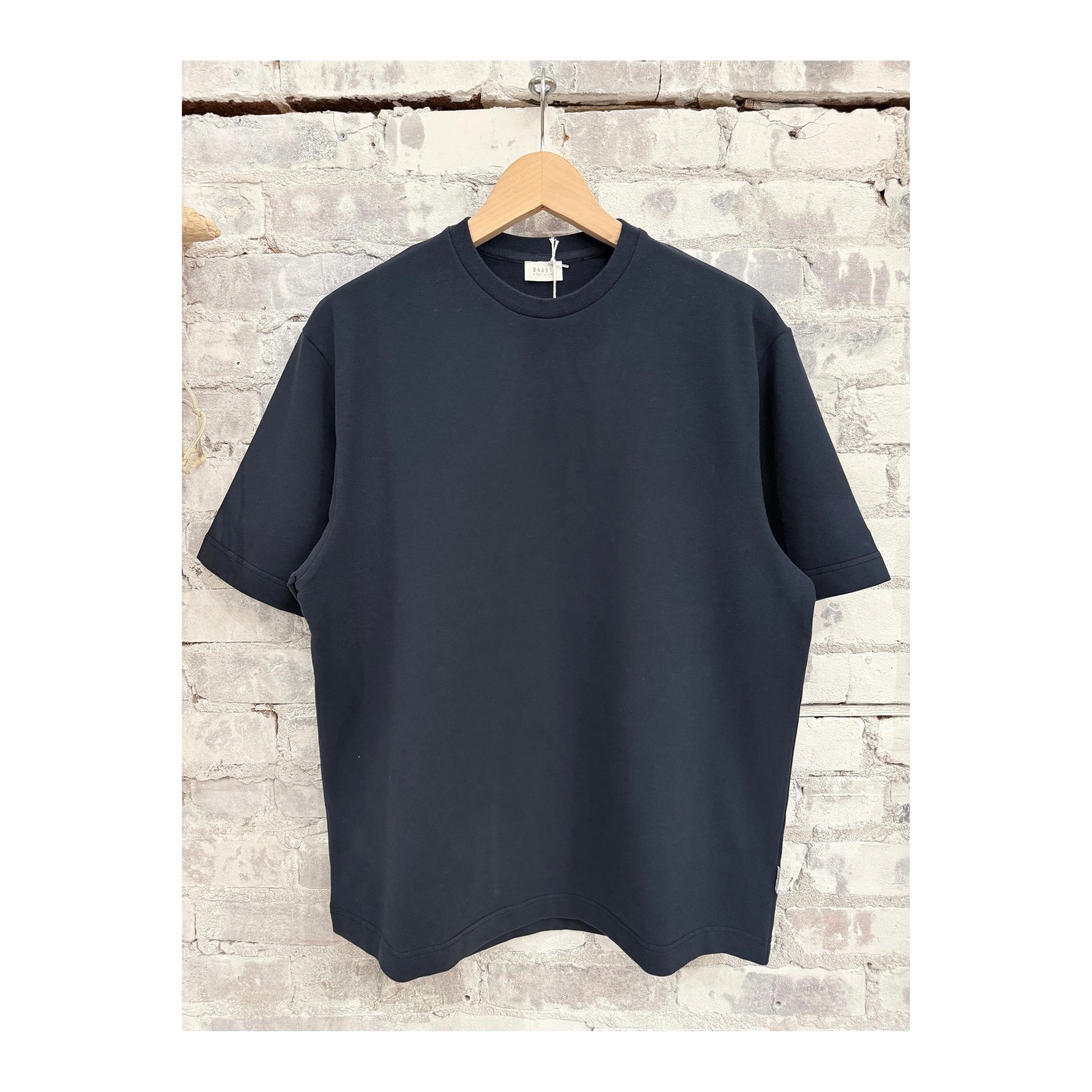 Men's navy IF Tee by 04651/ displayed on a hanger, showcasing a simple, classic crew neck design in a solid navy color.