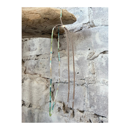 A Julie Rofman JRN1 Aqua glass beaded adjustable necklace hanging against a white background.