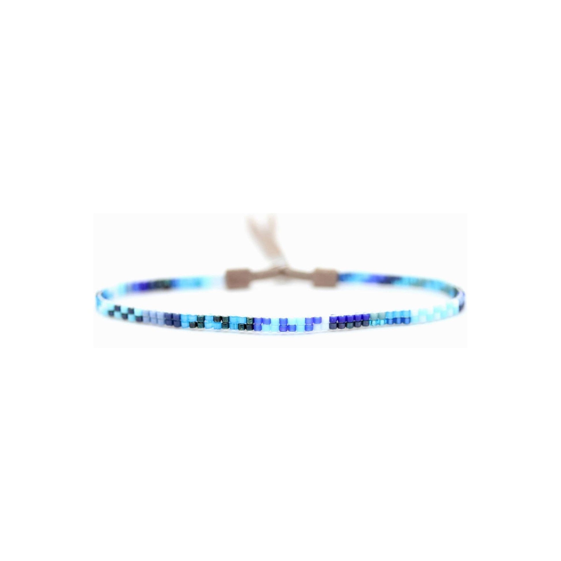 Blue mini bracelet by Julie Rofman featuring delicate jewelry design with small, vibrant blue beads.
